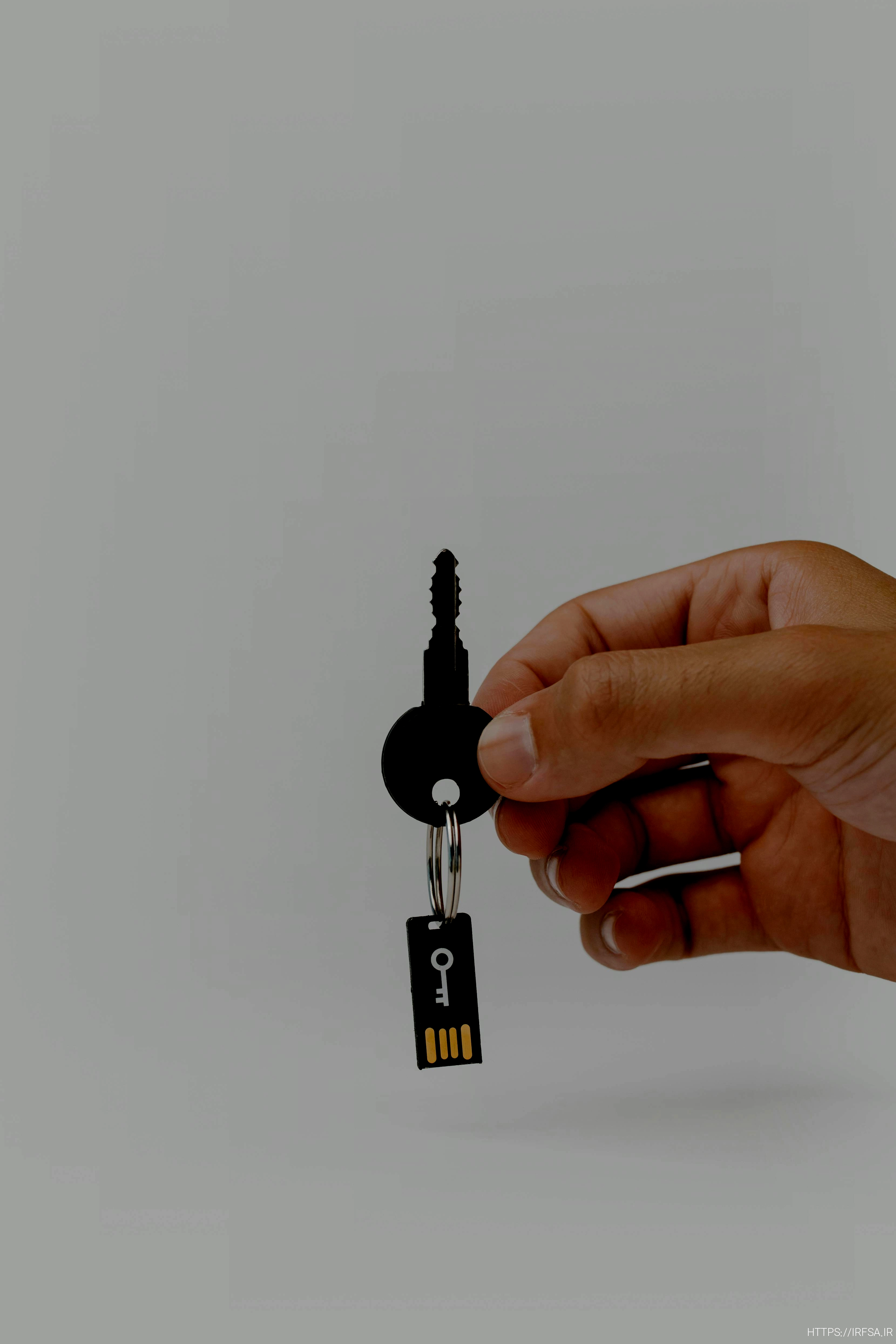 hand holding a key with a usb flash drive